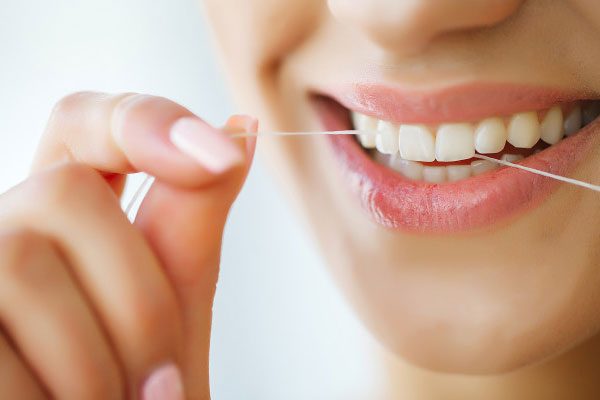 dental-care-woman-with-beautiful-smile-using-floss-teeth-image_118454-4125